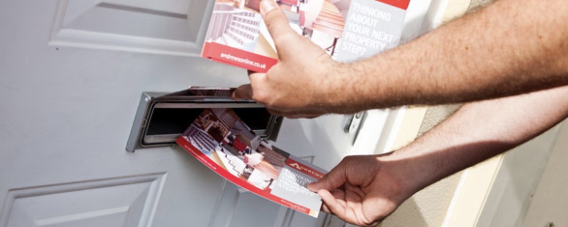 Close-up of leaflets being delivered through a letterbox